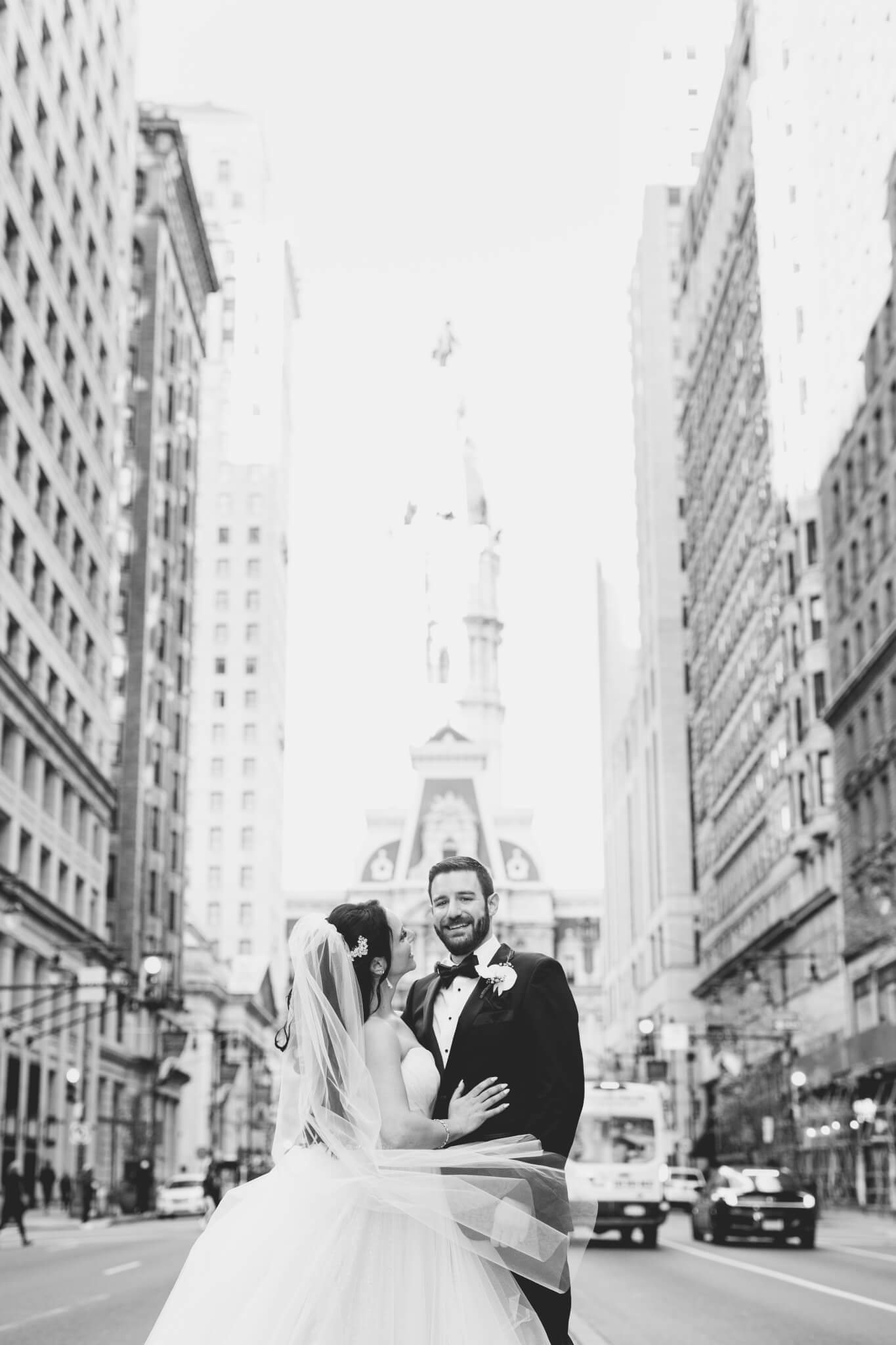 A bride and groom stand on Broad Street, Philadelphia.
