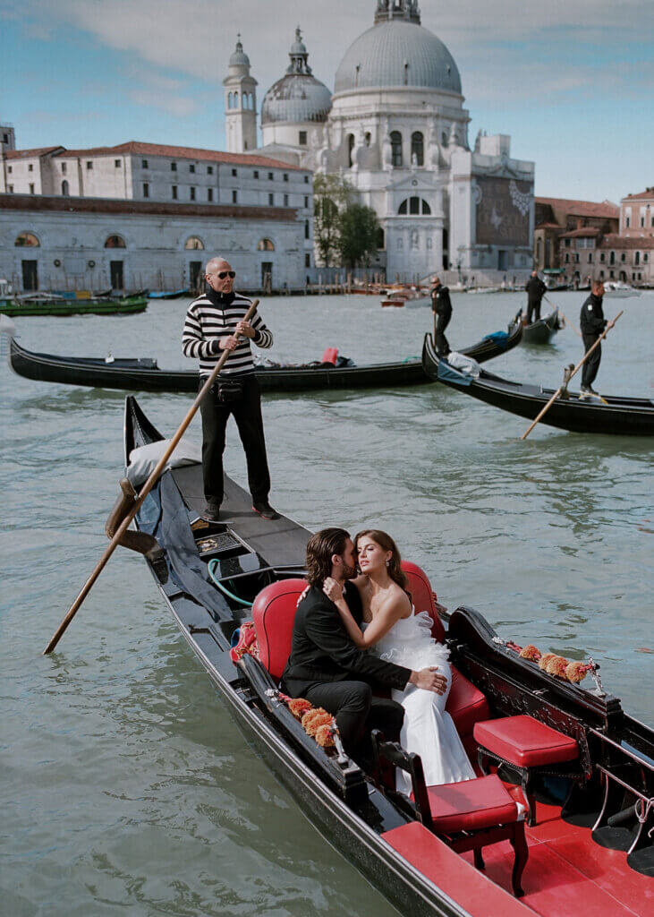 A Bride and Groom embrace on the gondola at the Hotel Monaco & Grand Canal at their destination wedding in Venice, Italy.