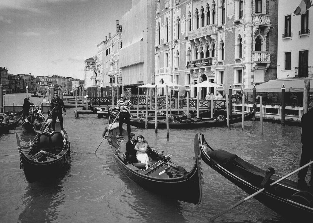 A Bride and Groom embrace on the gondola at the Hotel Monaco & Grand Canal in Venice, Italy.