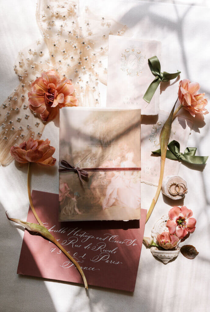 The antique flat lay with rose colored details, white gloves, and scripted stationary at a Destination Wedding in Venice, Italy.