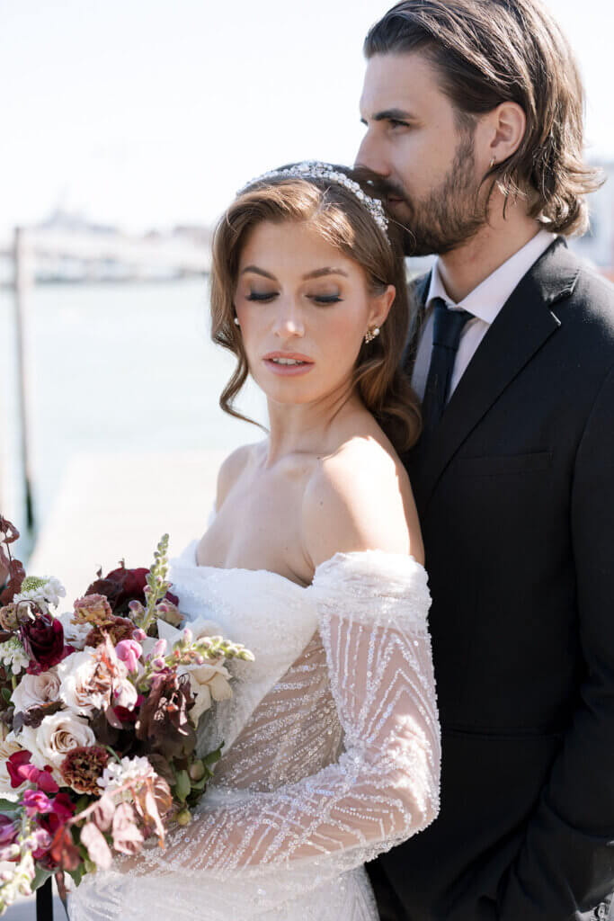 A Bride and Groom embrace on the deck at the Hotel Monaco & Grand Canal at their destination wedding in Venice, Italy.