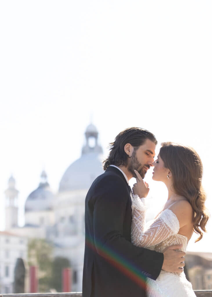 A portrait of the bride and groom kissing on the water at their Destination Wedding in Venice, Italy.