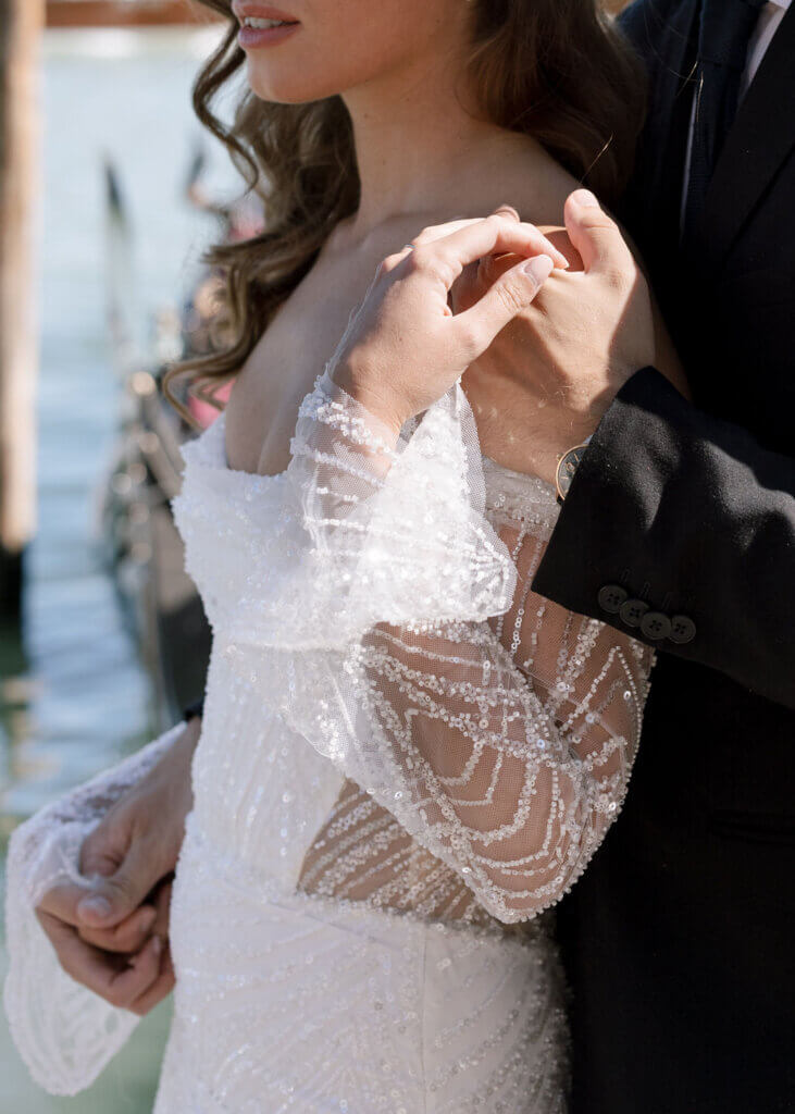 A Bride and Groom hold hands on the deck at the Hotel Monaco & Grand Canal at their destination wedding in Venice, Italy.