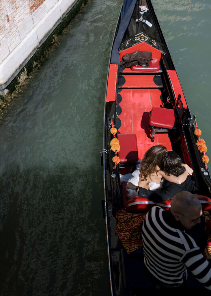 A Bride and Groom embrace on the gondola at the Hotel Monaco & Grand Canal in Venice, Italy.