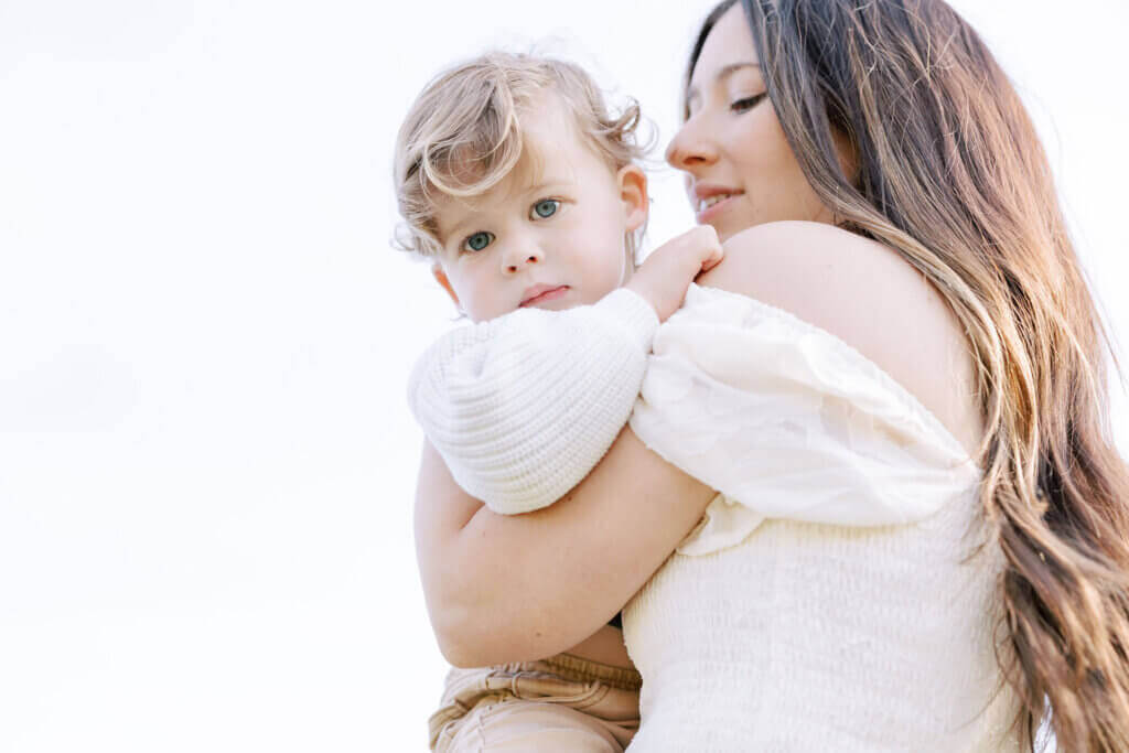 At a maternity session in Doylestown, Pennsylvania, a pregnant mother holds her older child over her shoulder.