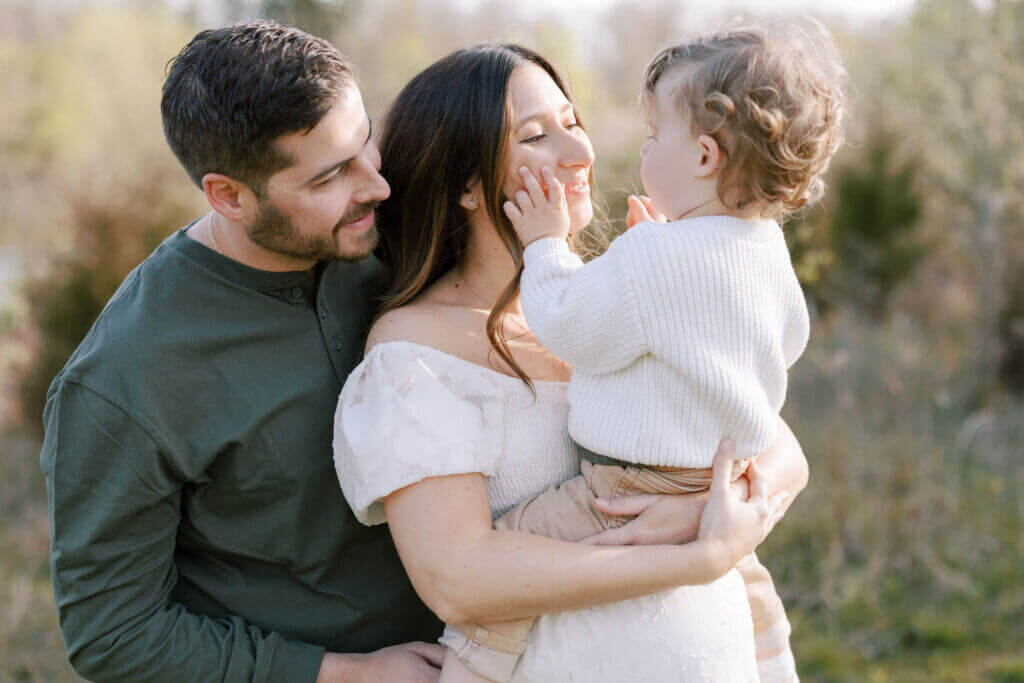 At a maternity session in Doylestown, Pennsylvania, two parents hold their older child.