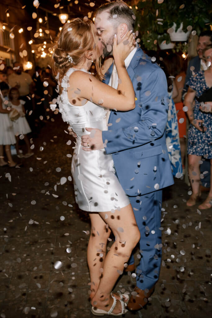 The bride and groom kiss as confetti falls around them at the end of their reception at Riverdale Manor in Lancaster, Pennsylvania.