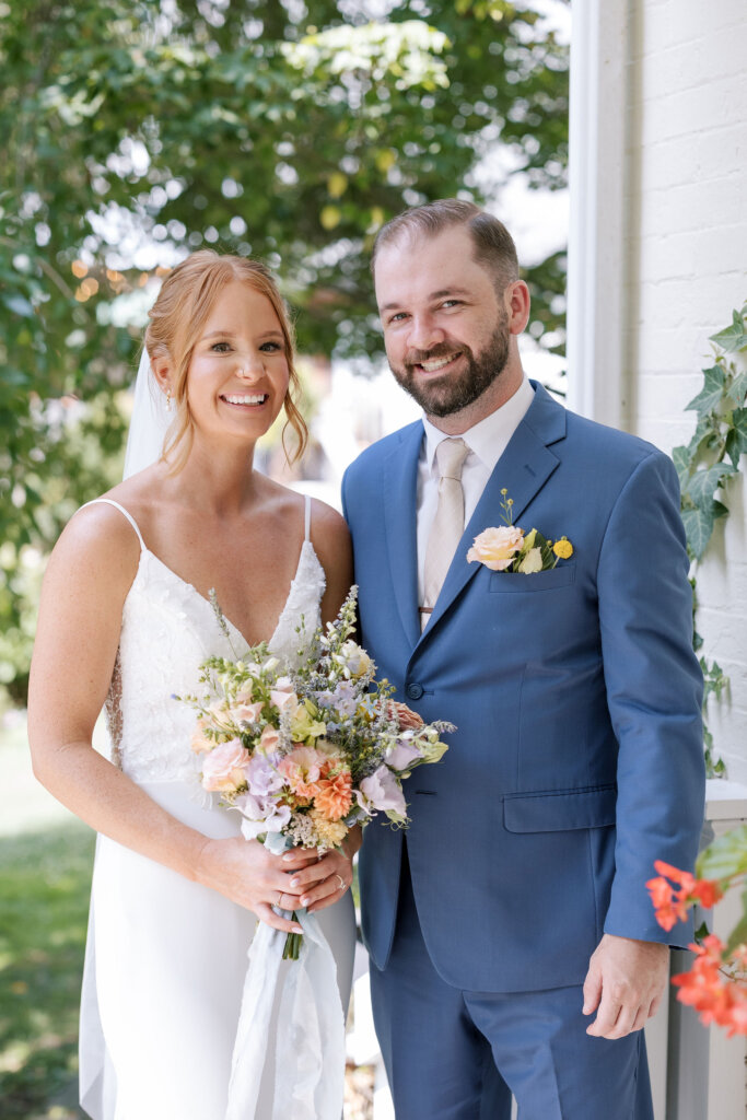 The bride and groom pose on the porch of the main house at Riverdale Manor in Lancaster, Pennsylvania.