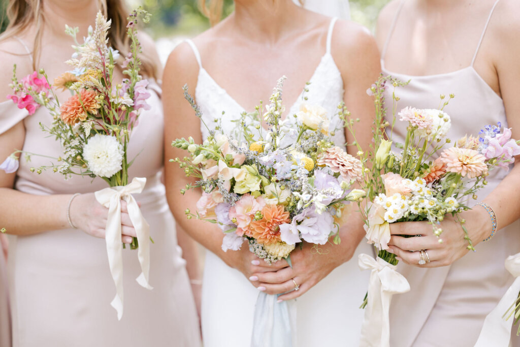 A close-up of the bride and two bridesmaids displaying their bouquets on her wedding day at Riverdale Manor in Lancaster, Pennsylvania.