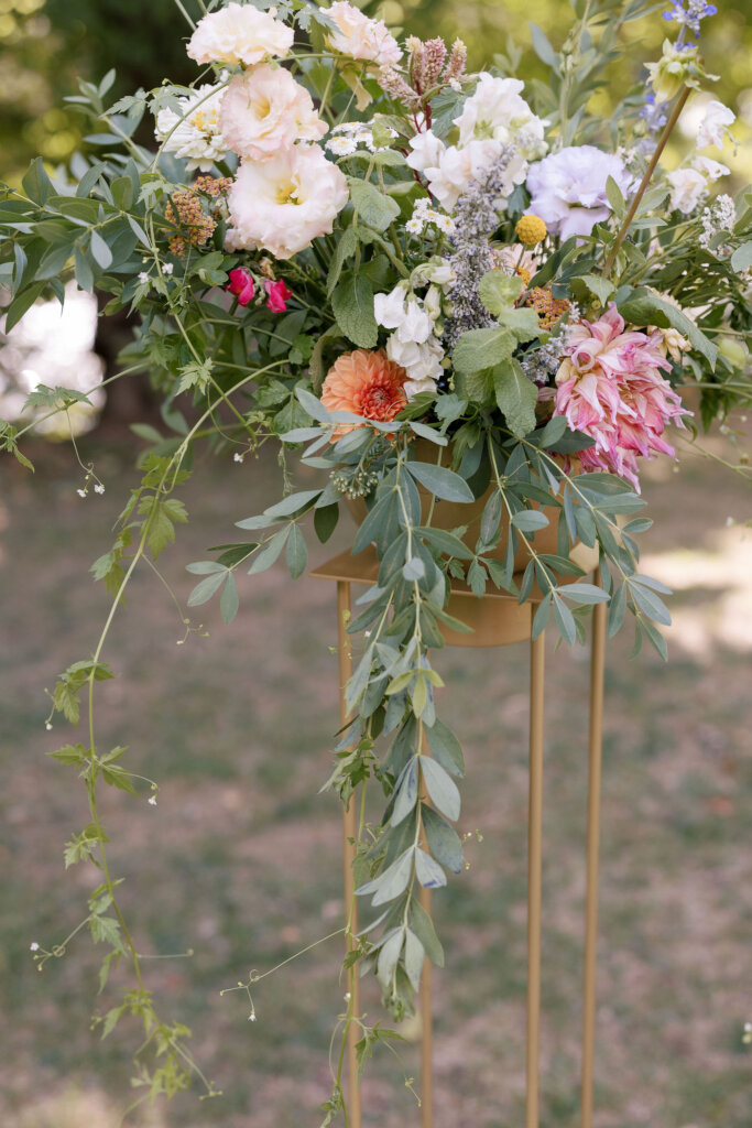 A close-up of a beautiful wildflower bouquet on a pedestal for a wedding ceremony at Riverdale Manor in Lancaster, Pennsylvania.