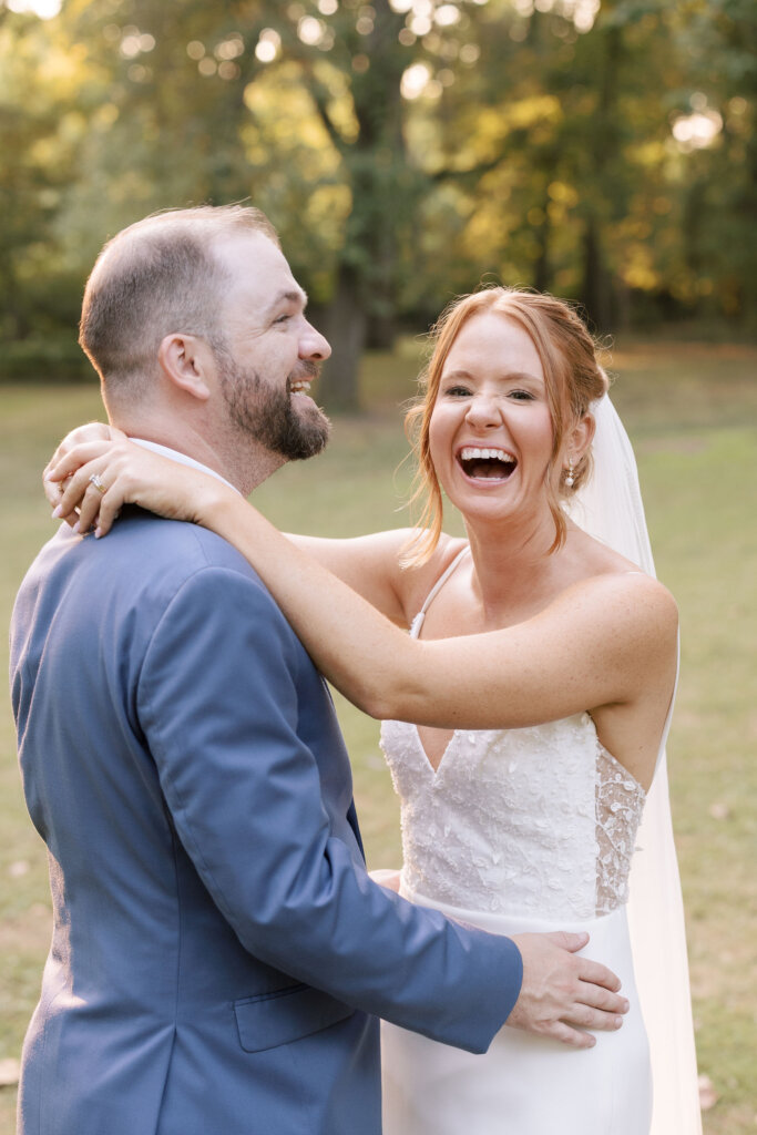 A bride laughing with the groom on the grounds of Riverdale Manor in Lancaster, Pennsylvania.