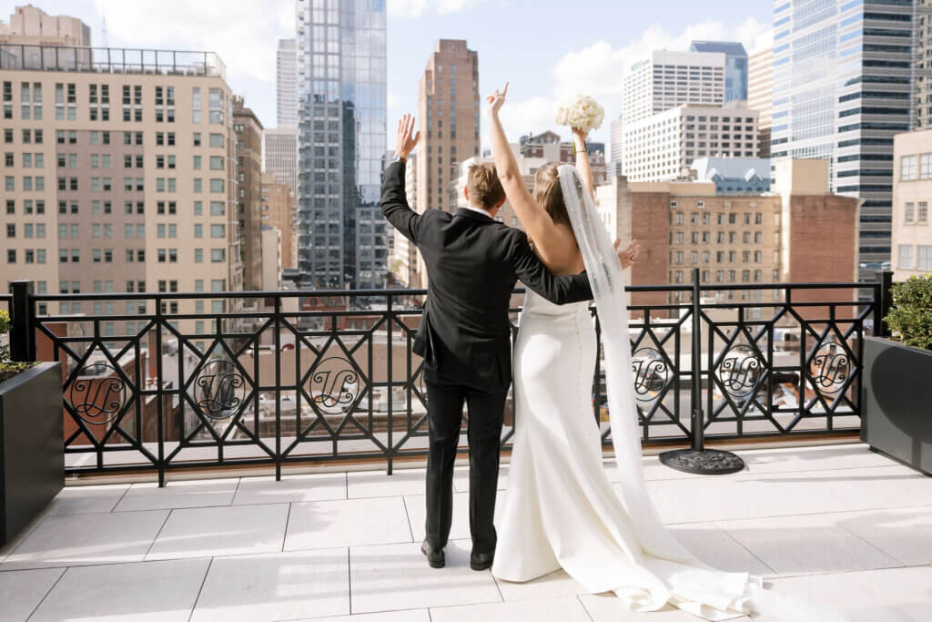 A landscape portrait of the bride and groom looking at a view of Philadelphia.