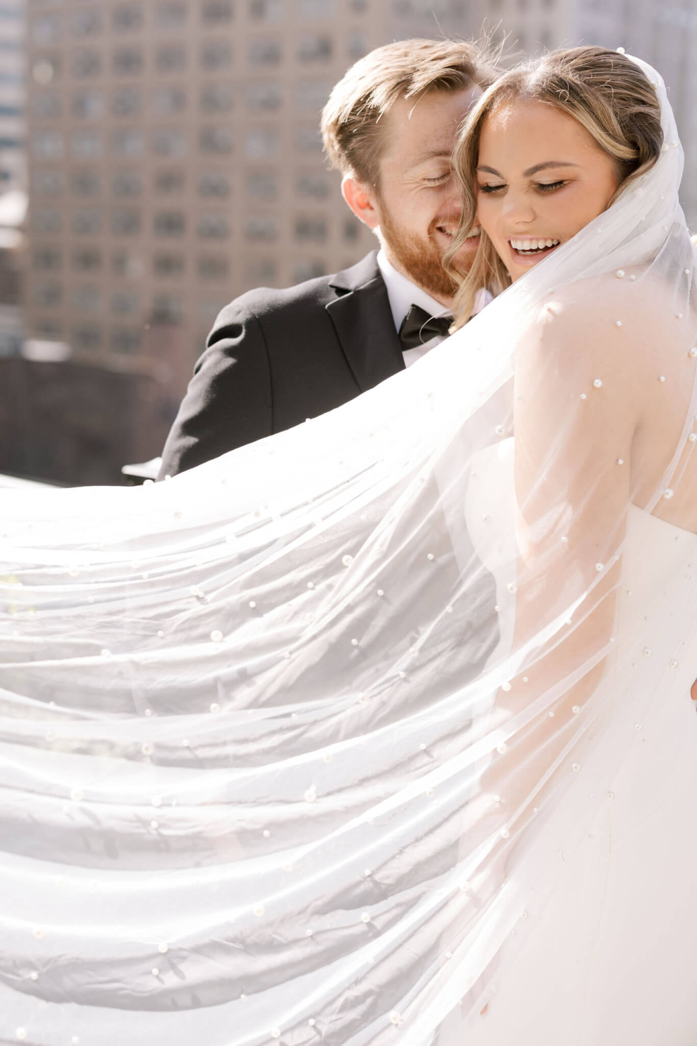 The bride and groom laughing on the roof.