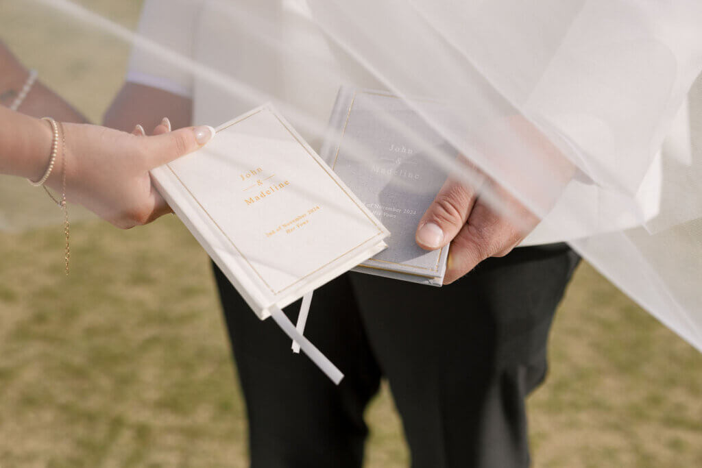 The bride and groom share vow books during their first look at The Rehoboth beach Country Club.