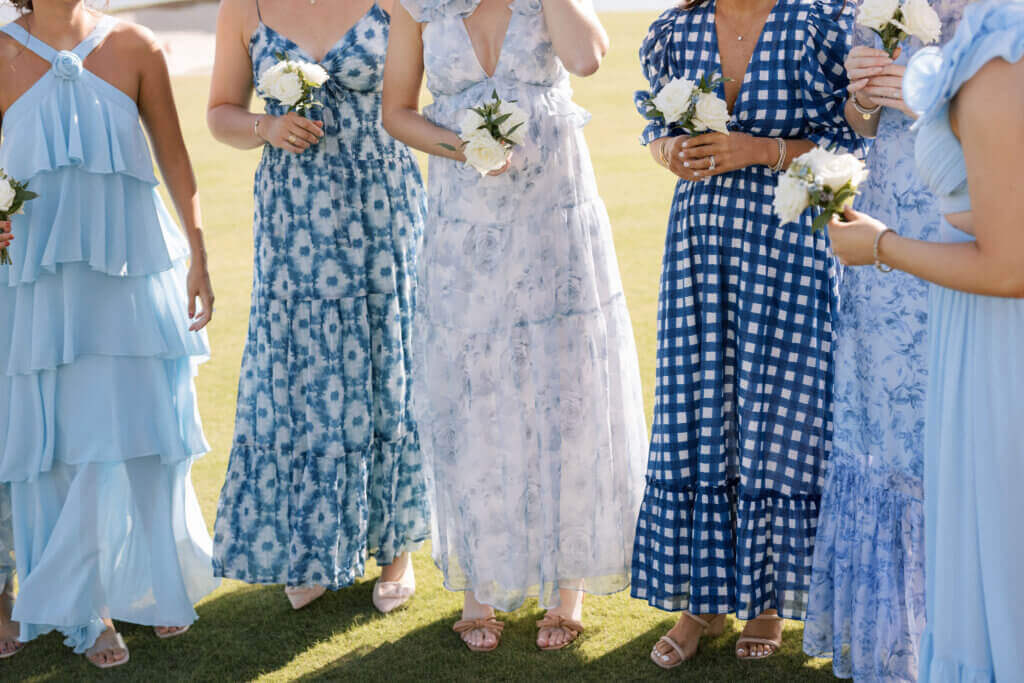 The bridesmaids in printed dresses help with the bride's veil at the Rehoboth Beach Country Club.