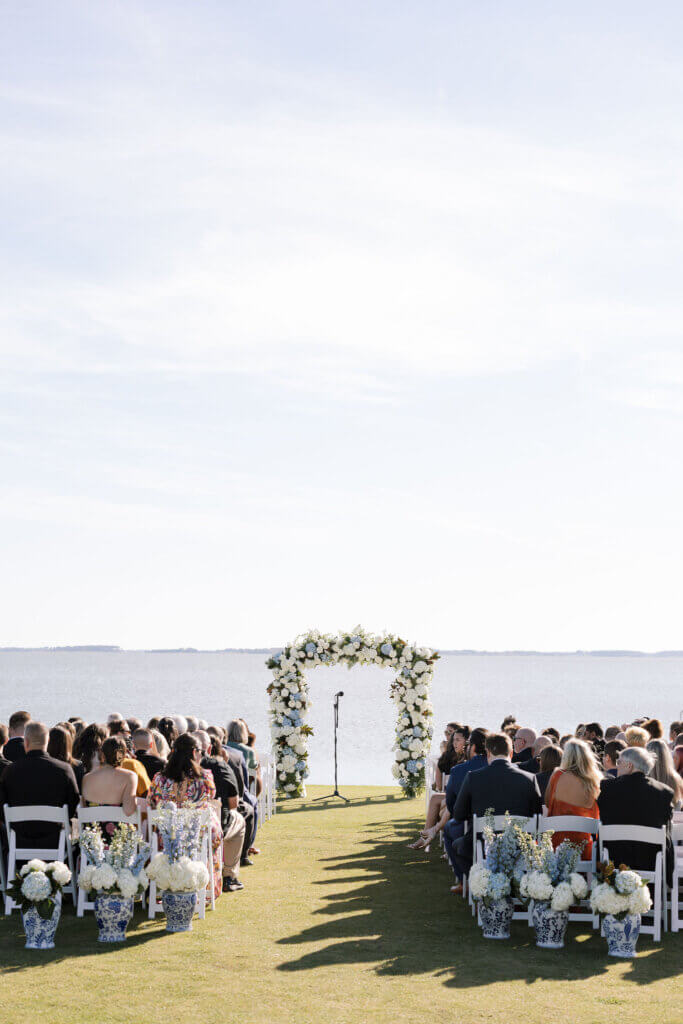 Large blue and white florals adorn the arbor for the ceremony on the water at Rehoboth Beach Country Club. 