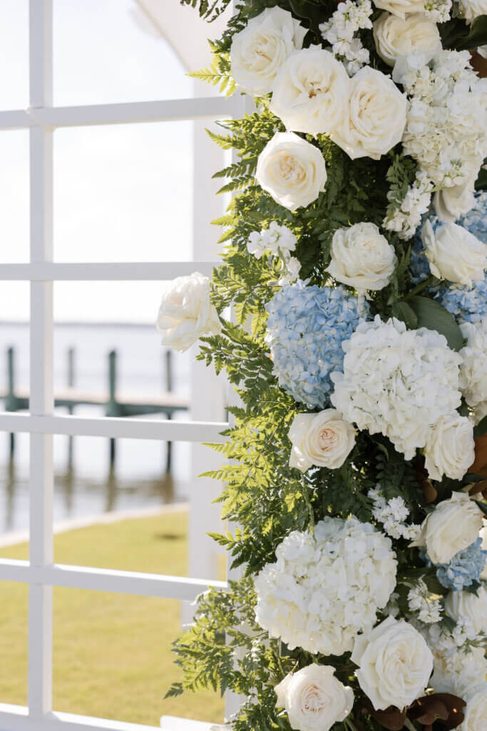 Large blue and white florals adorn the arbor for the ceremony at Rehoboth Beach Country Club. 