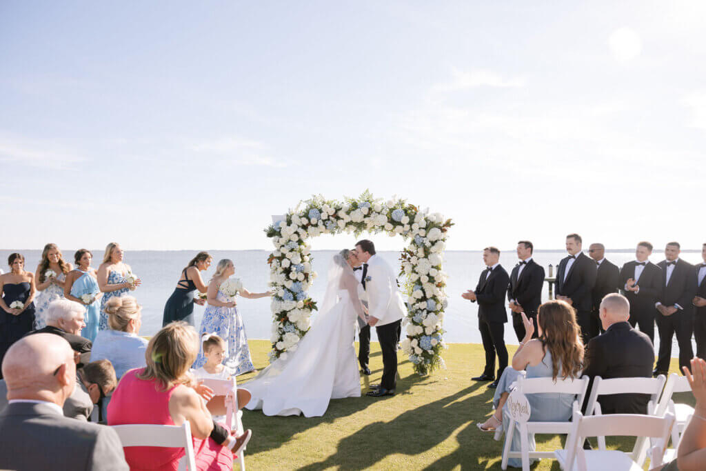 The bride and groom share their first kiss at their ceremony at Rehoboth Beach Country Club. 