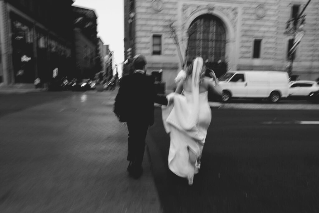 The bride and groom walk along Broad Street before their wedding at the Crystal Tea Room.