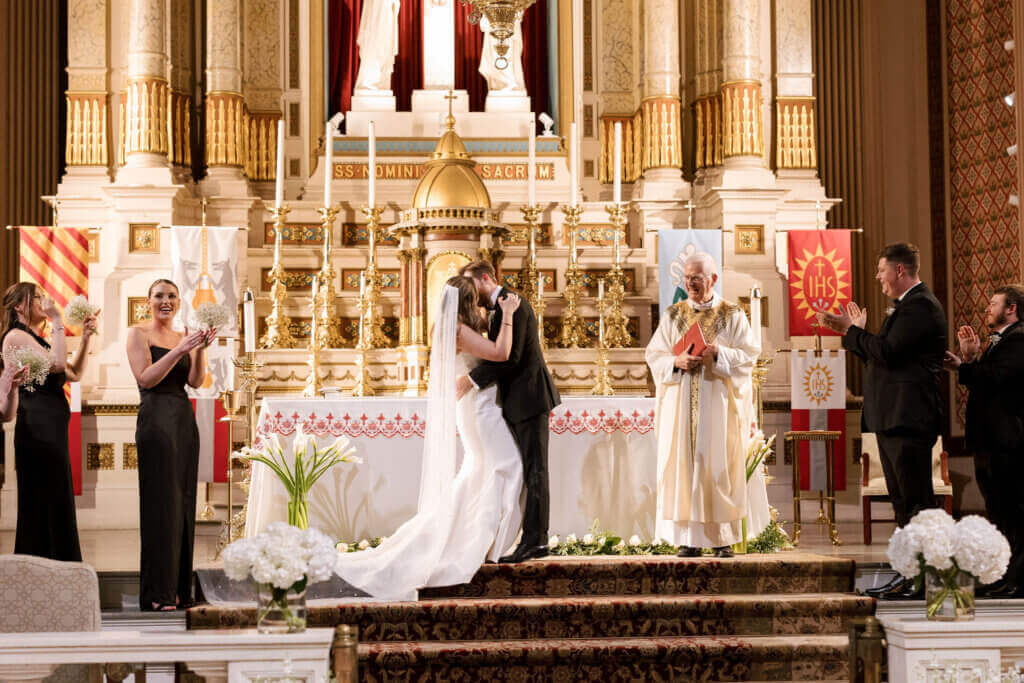 The bride and groom do a Catholic ceremony before their wedding at the Crystal Tea Room.