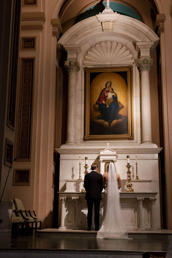 The bride and groom do a Catholic ceremony before their wedding at the Crystal Tea Room.