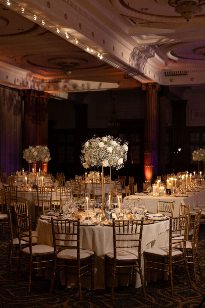 The floral centerpieces are dimly lit and dramatic at the Crystal Tea Room by Finley Catering.