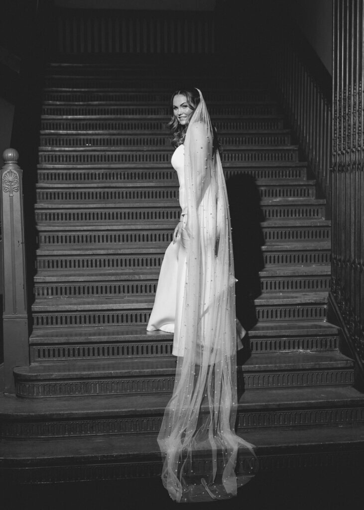 The bride has a candid moment on the amazing turquoise steps at the Crystal Team Room by Finley Catering.