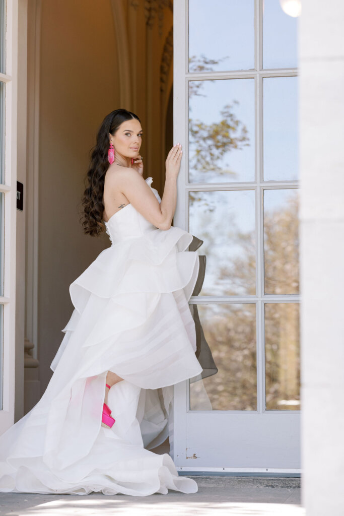 The bride poses in pink heels outside of Elkins Estate. 