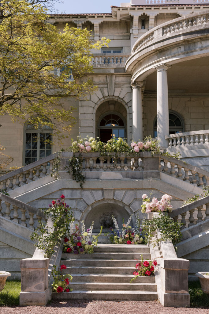 Lush florals drape the exterior of Elkins Estate for a ceremony outside by the grand staircase.