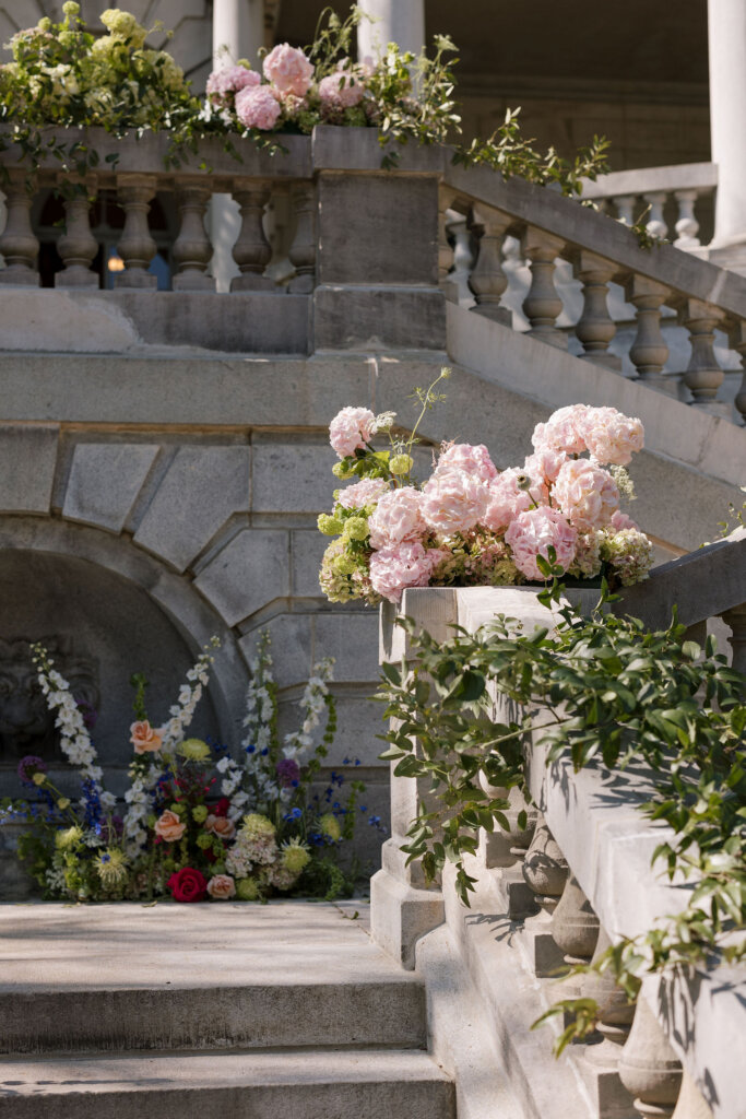 Lush florals drape the exterior of Elkins Estate for a ceremony outside by the grand staircase.