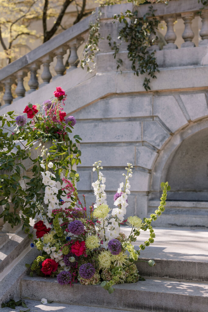 Lush florals drape the exterior of Elkins Estate for a ceremony outside by the grand staircase.